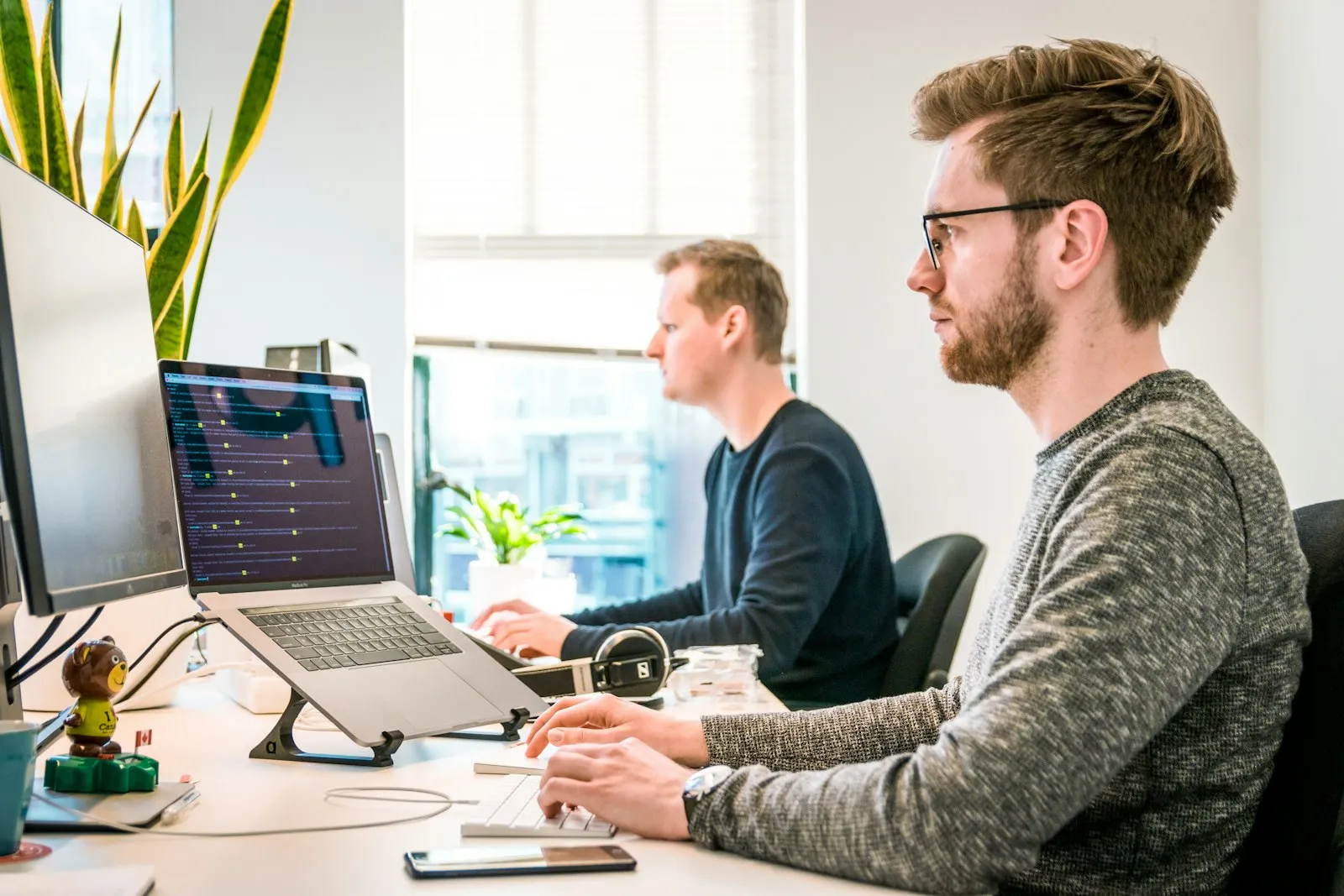 Two IT technicians working side by side at their desks